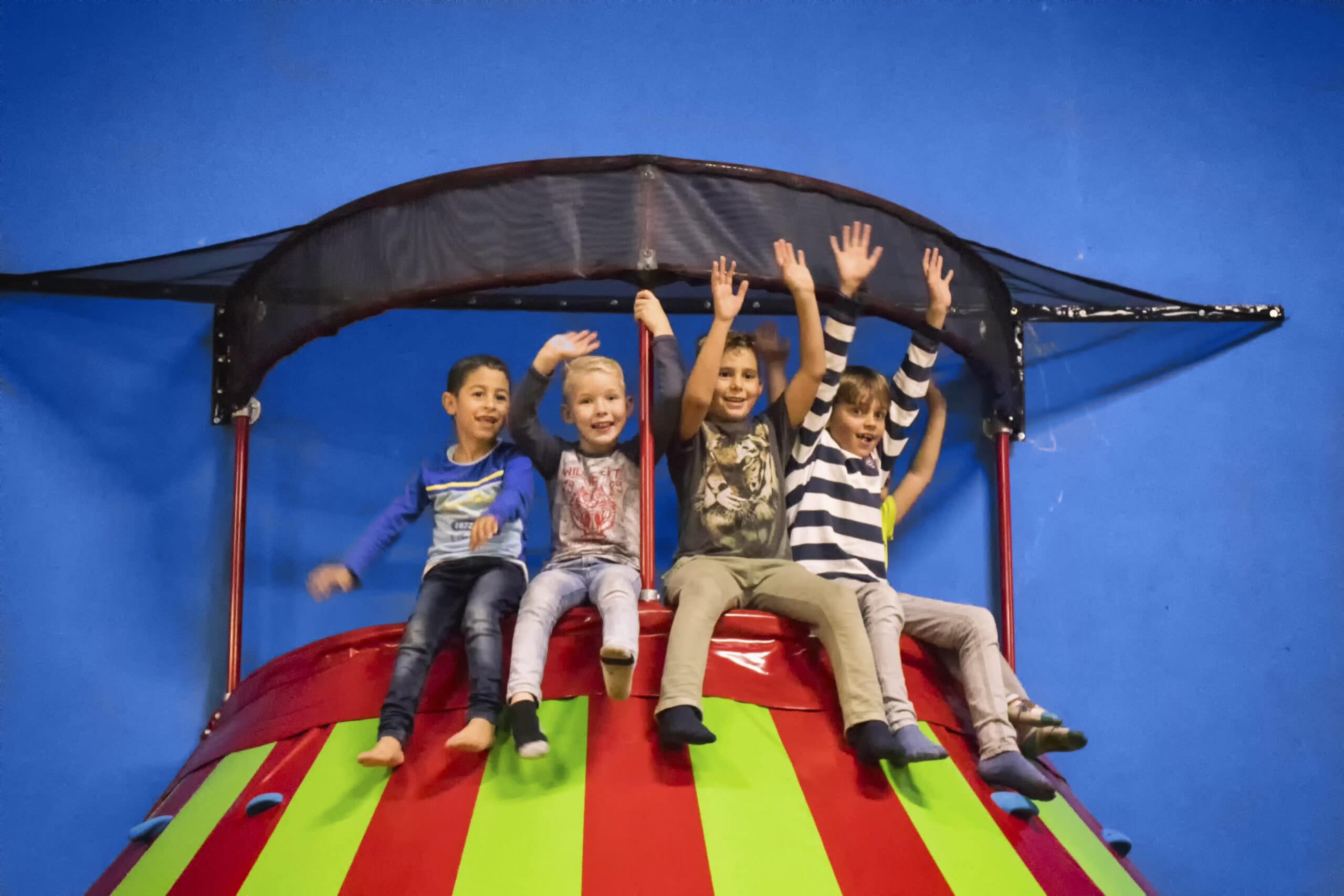 Bovenop de klautertoren zitten blije kinderen bij Jimmy's Speelparadijs in Amsterdam
