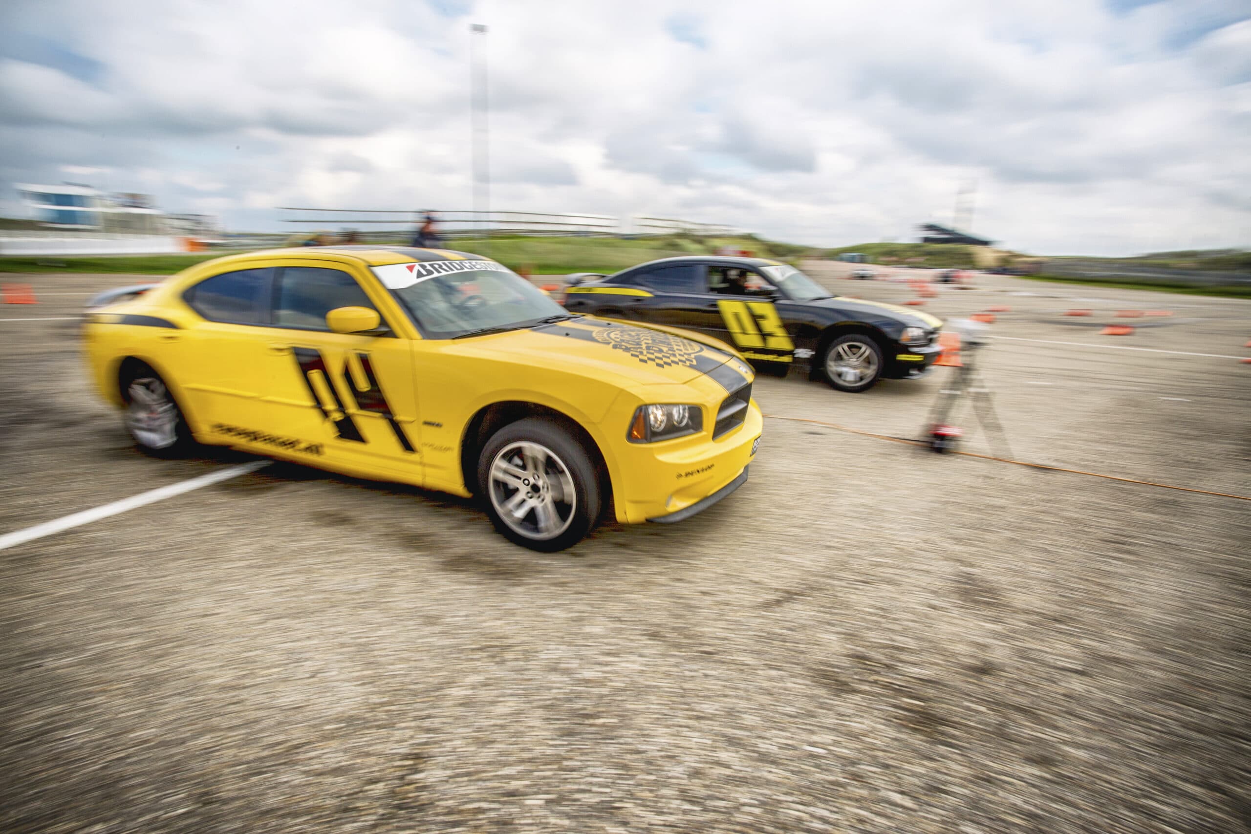 Twee deelnemers in Dodge Chargers strijden tegen elkaar in de dragrace om de overwinning op Circuit Zandvoort tijdens een Race Experience.