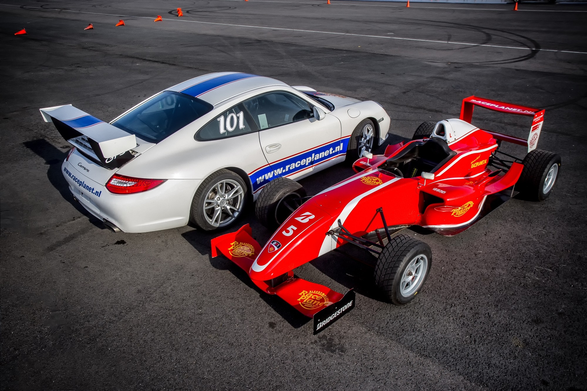 Deelnemers rijden met de Porsche 911 en Formule RP1 raceauto op Circuit Zandvoort tijdens de Driving Experience van Race Planet