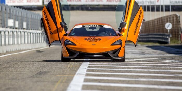 Oranje McLaren 540C in de pitstraat waarin een deelnemer zelf rijdt op Circuit Zandvoort tijdens de Race Experiences van Race Planet