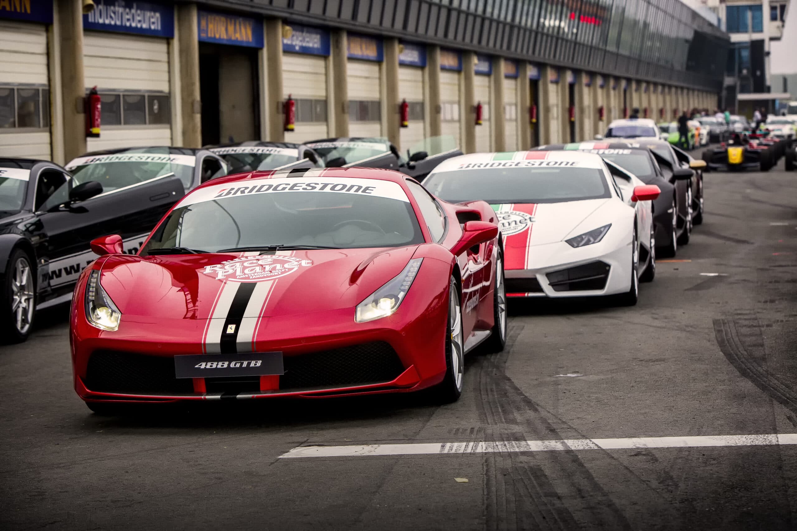 Ferrari 488 GTB, Lamborghini's, Aston Martin en andere sportwagen staan klaar voor deelnemers aan de Platinum Experience op Circuit Zandvoort.