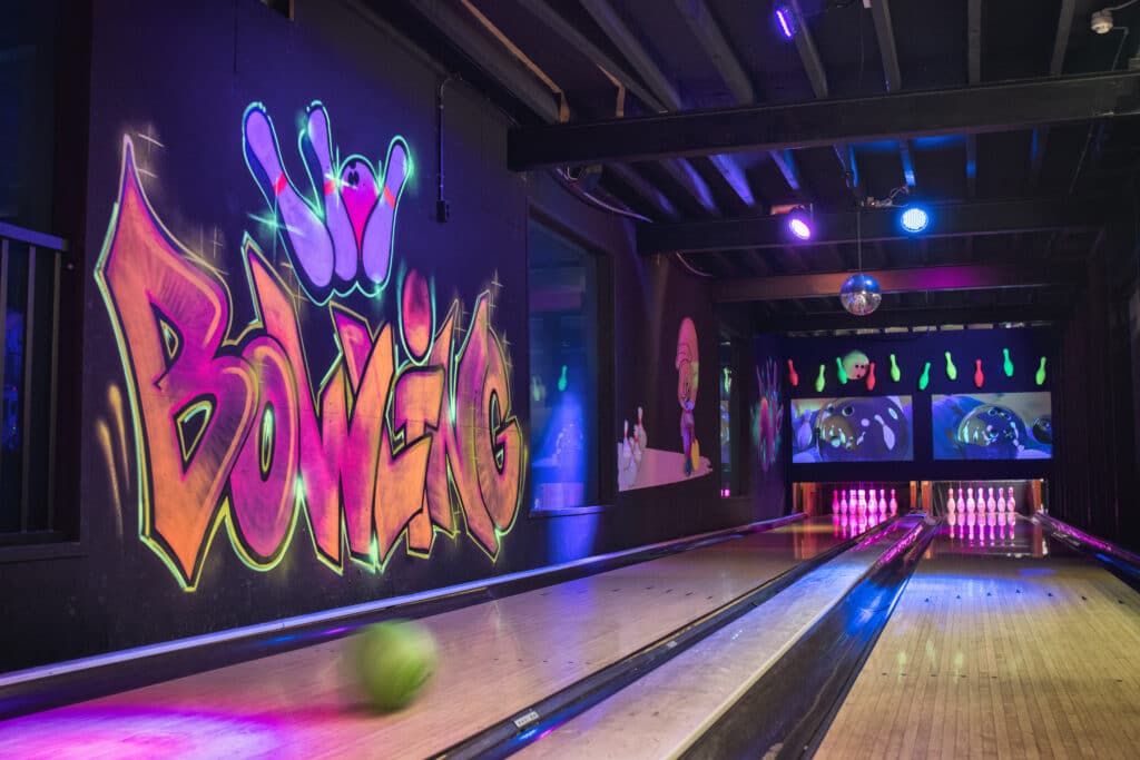 Bezoeker gooit een bowlingbal op de bowlingbaan bij Race Planet Amsterdam en Delft.